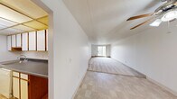 Located at 5900 Bridge Rd in Ypsilanti, Michigan, this two-bedroom, one-bathroom residence offers a practical and functional single-floor layout. The open living area features a combination of tile flooring near the entry and plush carpeting throughout, with a textured ceiling and a ceiling fan adding character to the space. A sliding glass door at the far end of the living area floods the room with natural light and provides access to a balcony with outdoor views.

The galley-style kitchen is efficiently designed with white cabinetry trimmed in warm wood tones, dark countertops, and a full suite of appliances including a refrigerator, stove, and dishwasher. A drop ceiling with recessed lighting and tile flooring complete the kitchen's clean, utilitarian aesthetic.

The generously sized primary bedroom offers ample space and features a large sliding glass door with vertical blinds, providing natural light and an elevated exterior view. The second bedroom is a cozy, carpeted room with clean white walls. A dedicated closet offers convenient storage.

The bathroom includes a full tub-and-shower combination with white tile surround and chrome fixtures. A hallway connects the main living spaces, contributing to a cohesive and well-organized floor plan throughout the residence.