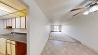 Located at 5900 Bridge Rd in Ypsilanti, Michigan, this two-bedroom, one-bathroom residence offers a practical and functional single-floor layout. The open living area features a combination of tile flooring near the entry and plush carpeting throughout, with a textured ceiling and a ceiling fan adding character to the space. A sliding glass door at the far end of the living area floods the room with natural light and provides access to a balcony with outdoor views.

The galley-style kitchen is efficiently designed with white cabinetry trimmed in warm wood tones, dark countertops, and a full suite of appliances including a refrigerator, stove, and dishwasher. A drop ceiling with recessed lighting and tile flooring complete the kitchen's clean, utilitarian aesthetic.

The generously sized primary bedroom offers ample space and features a large sliding glass door with vertical blinds, providing natural light and an elevated exterior view. The second bedroom is a cozy, carpeted room with clean white walls. A dedicated closet offers convenient storage.

The bathroom includes a full tub-and-shower combination with white tile surround and chrome fixtures. A hallway connects the main living spaces, contributing to a cohesive and well-organized floor plan throughout the residence.