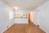 Located at 1500 E Cherry Street in Seattle's vibrant Capitol Hill neighborhood, Unit 201 is a thoughtfully designed second-floor residence that offers a clean, functional layout across a single level. Warm hardwood-style flooring flows consistently throughout the unit, lending a cohesive and inviting feel to every room.

The open living area is bright and airy, benefiting from multiple windows dressed with blinds that allow natural light to filter in. A pass-through counter connects the living space to the kitchen, creating an open and communicative layout ideal for everyday living. The kitchen is efficiently arranged with white cabinetry extending to the ceiling for generous storage, a gray countertop with an undermount stainless steel sink, and a full-size white refrigerator.

A dedicated bedroom offers a quiet retreat, featuring a large window that brings in natural light and provides views of the surrounding neighborhood. The textured ceiling is consistent throughout the unit, adding a classic residential character.

The full bathroom is clean and well-maintained, featuring a combination tub and shower, a single-sink vanity with white cabinetry and a gray countertop, a framed mirror, and stylish brushed nickel light fixtures. A central hallway connects the rooms efficiently, completing this practical and comfortable Seattle residence.