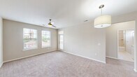 This well-appointed 3-bedroom, 2-bathroom single-story home in Columbia, SC offers a thoughtfully designed layout with a blend of modern finishes and comfortable living spaces. The kitchen serves as the centerpiece, showcasing rich dark cabinetry, a mosaic tile backsplash, granite countertops, stainless steel appliances, and a large island with pendant lighting overhead — all set atop durable hardwood-style flooring. The open layout connects the kitchen seamlessly to the living areas, which feature plush carpeting, ceiling fans, and multiple windows that fill the space with natural light. Each of the three bedrooms is carpeted and equipped with a ceiling fan, offering a comfortable and airy atmosphere. The primary bedroom includes access to a spacious walk-in closet with built-in wire shelving. The two bathrooms are finished with tile flooring, dark vanity cabinetry, and granite countertops. The primary bath features a dual-sink vanity and a tiled tub-shower surround, while the second bath mirrors the same quality finishes. Three closets throughout the home provide ample storage. A connecting hallway ties all rooms together in a practical and efficient floor plan, making this home a functional and stylish residence in the Columbia, SC area.