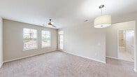 This well-appointed 3-bedroom, 2-bathroom single-story home in Columbia, SC offers a thoughtfully designed layout with a blend of modern finishes and comfortable living spaces. The kitchen serves as the centerpiece, showcasing rich dark cabinetry, a mosaic tile backsplash, granite countertops, stainless steel appliances, and a large island with pendant lighting overhead — all set atop durable hardwood-style flooring. The open layout connects the kitchen seamlessly to the living areas, which feature plush carpeting, ceiling fans, and multiple windows that fill the space with natural light. Each of the three bedrooms is carpeted and equipped with a ceiling fan, offering a comfortable and airy atmosphere. The primary bedroom includes access to a spacious walk-in closet with built-in wire shelving. The two bathrooms are finished with tile flooring, dark vanity cabinetry, and granite countertops. The primary bath features a dual-sink vanity and a tiled tub-shower surround, while the second bath mirrors the same quality finishes. Three closets throughout the home provide ample storage. A connecting hallway ties all rooms together in a practical and efficient floor plan, making this home a functional and stylish residence in the Columbia, SC area.