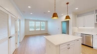Located in Collierville, TN, this well-appointed 2-bedroom, 3-bathroom single-floor residence offers a thoughtfully designed open-concept layout with a clean, contemporary aesthetic throughout. Light oak hardwood flooring flows seamlessly across the living spaces, complementing crisp white walls and crown molding details.

The kitchen serves as a central hub, showcasing white shaker-style cabinetry extending to the ceiling, gleaming white quartz countertops, a central island, and stainless steel appliances including a range, microwave, dishwasher, and French door refrigerator. Striking gold pendant lights add a warm, stylish accent above the island.

The open living area benefits from a generous bank of windows, filling the space with natural light and offering views of the surrounding neighborhood. The spacious primary bedroom features a ceiling fan, multiple windows, and direct access to a well-appointed en-suite bathroom complete with a dual-sink vanity, marble-look tile flooring, and a glass-enclosed shower. A walk-in closet with wire shelving provides ample storage. The second bedroom is equally bright, with multiple windows and hardwood flooring. Three full bathrooms ensure convenience for residents and guests alike. The overall ambiance is light, airy, and move-in ready.