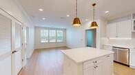 Located in Collierville, TN, this well-appointed 2-bedroom, 3-bathroom single-floor residence offers a thoughtfully designed open-concept layout with a clean, contemporary aesthetic throughout. Light oak hardwood flooring flows seamlessly across the living spaces, complementing crisp white walls and crown molding details.

The kitchen serves as a central hub, showcasing white shaker-style cabinetry extending to the ceiling, gleaming white quartz countertops, a central island, and stainless steel appliances including a range, microwave, dishwasher, and French door refrigerator. Striking gold pendant lights add a warm, stylish accent above the island.

The open living area benefits from a generous bank of windows, filling the space with natural light and offering views of the surrounding neighborhood. The spacious primary bedroom features a ceiling fan, multiple windows, and direct access to a well-appointed en-suite bathroom complete with a dual-sink vanity, marble-look tile flooring, and a glass-enclosed shower. A walk-in closet with wire shelving provides ample storage. The second bedroom is equally bright, with multiple windows and hardwood flooring. Three full bathrooms ensure convenience for residents and guests alike. The overall ambiance is light, airy, and move-in ready.