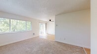 This 630 square foot apartment offers a thoughtful layout in a single-floor design. The space features one bedroom measuring 140 square feet, providing a cozy retreat. The living area is open and airy, with large windows that flood the space with natural light and offer pleasant views of the surrounding greenery.

The kitchen is a highlight, boasting a galley-style layout with ample counter space and storage. White cabinetry contrasts nicely with stainless steel appliances and light-colored countertops. The wood-look flooring in the kitchen and living areas adds warmth to the space.

The bathroom is efficiently designed, featuring a combination tub and shower with white tile surround, a single vanity, and modern fixtures. The apartment also includes a closet for additional storage.

Throughout the apartment, neutral-toned carpeting in the bedroom and living areas creates a soft, comfortable atmosphere. The overall color palette of whites and light tones contributes to a sense of spaciousness and cleanliness.

This apartment combines functionality with modern aesthetics, making efficient use of its 630 square feet to provide a comfortable living space. The balance of shared living areas with private spaces makes it an ideal choice for individuals or couples seeking a well-designed, compact home.