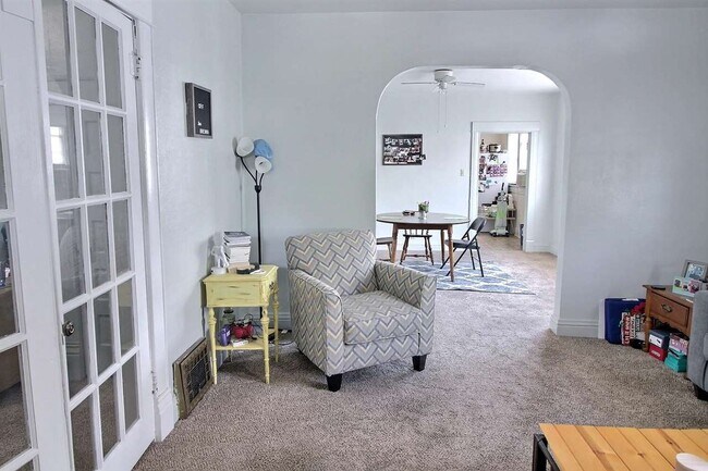Unit 1 - Living room with french doors to bedroom. - 103 W 7th Ave