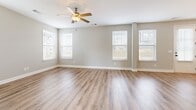 Located at 1104 Spring Path Ln in Nashville, Tennessee, this two-story home offers four bedrooms and four full bathrooms across two well-proportioned floors. The main level houses the combined kitchen and living area, complemented by a spacious attached garage with a polished concrete floor and an automatic opener. The kitchen is outfitted with light gray shaker-style cabinetry, white quartz countertops, stainless steel appliances including an electric range and over-the-range microwave, and a undermount sink beneath a bright window. Light wood-look flooring runs throughout, contributing to a clean, cohesive aesthetic. The living area features vaulted ceilings and a ceiling fan, allowing natural light to fill the space through multiple windows. The upper floor hosts the four bedrooms, including a generously sized primary suite with vaulted ceilings, a walk-in closet with wire shelving, and a private en-suite bathroom featuring a glass-enclosed shower. Additional bedrooms are bright and well-sized, each with natural light from windows. A dedicated laundry room includes built-in cabinetry with a countertop workspace and overhead wire shelving. Throughout the home, neutral gray walls, white trim, and consistent flooring create a modern, move-in-ready environment.