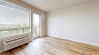 Located at 17270 W Colfax Ave in Golden, Colorado, this single-floor unit offers a thoughtfully designed layout that maximizes every square foot. Light hardwood-style flooring runs throughout, lending a warm, cohesive feel to the entire space.

The open living area is bright and airy, with large windows fitted with horizontal blinds that frame views of the surrounding Colorado landscape. A sliding glass door opens to a private balcony with a modern metal railing, allowing natural light to flood the interior. A wall-mounted PTAC unit provides convenient climate control.

The kitchen is efficiently arranged and features stainless steel appliances, including a refrigerator and range, complemented by warm wood-toned cabinetry. The layout connects seamlessly to the living area, creating a functional and open feel.

The bathroom is finished in crisp white subway-style tile and includes a soaking tub with a shower, outfitted with polished chrome fixtures for a clean, contemporary look.

A dedicated laundry area houses a stacked Whirlpool washer and dryer, making laundry convenient and easy. Wire shelving provides additional storage in this space.

Clean white walls, consistent flooring, and modern fixtures throughout give this unit a fresh, move-in-ready character well-suited for comfortable everyday living in the Golden area.