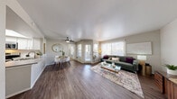 Located at 4000 E Bonanza Rd in Las Vegas, NV, this well-appointed 2-bedroom, 2-bathroom residence offers a thoughtfully designed single-floor layout. The open-concept living room is bathed in natural light from large windows dressed with sheer curtains and blinds, complemented by hardwood-style flooring that flows throughout the main living areas. The kitchen is equipped with stainless steel appliances, including a refrigerator, range, microwave, and dishwasher, alongside crisp white cabinetry and light stone-finish countertops. The spacious primary bedroom features plush carpeting and ample natural light, while the second bedroom includes mirrored sliding closet doors that enhance the sense of space. Both bathrooms are finished with white cabinetry, wide vanity countertops, wood-look tile flooring, and tub-shower combinations. A dedicated laundry area houses a full-size washer and dryer with additional shelving for storage. A separate closet provides further organizational space. The neutral color palette and clean finishes throughout give the home a bright, modern, and welcoming ambiance.