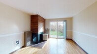 Located at 14095 SW Walker Rd in Beaverton, Oregon, this single-floor home offers a well-organized layout with consistent hardwood flooring throughout, creating a warm and cohesive feel across all living areas. The spacious main living area is a standout, featuring a striking wood-paneled fireplace that serves as a natural focal point. Large sliding glass doors flood the room with natural light and open directly onto a deck overlooking a green, landscaped backyard — ideal for indoor-outdoor living. A ceiling fan and track lighting add practical and aesthetic value to this generous entertaining space. The hallway connects the living area to the private quarters, where multiple bedrooms offer hardwood floors and windows that bring in abundant natural light with views of the surrounding neighborhood and greenery. The kitchen is equipped with warm maple cabinetry, dark countertops, a tile backsplash, a stainless steel sink, and a dishwasher, providing ample storage and a functional workspace. The bathroom features tile flooring, a vanity with storage, and a shower-tub combination with a sliding glass enclosure. Overall, the home presents a clean, functional, and inviting atmosphere well-suited for comfortable everyday living in the heart of Beaverton.