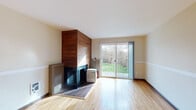 Located at 14095 SW Walker Rd in Beaverton, Oregon, this single-floor home offers a well-organized layout with consistent hardwood flooring throughout, creating a warm and cohesive feel across all living areas. The spacious main living area is a standout, featuring a striking wood-paneled fireplace that serves as a natural focal point. Large sliding glass doors flood the room with natural light and open directly onto a deck overlooking a green, landscaped backyard — ideal for indoor-outdoor living. A ceiling fan and track lighting add practical and aesthetic value to this generous entertaining space. The hallway connects the living area to the private quarters, where multiple bedrooms offer hardwood floors and windows that bring in abundant natural light with views of the surrounding neighborhood and greenery. The kitchen is equipped with warm maple cabinetry, dark countertops, a tile backsplash, a stainless steel sink, and a dishwasher, providing ample storage and a functional workspace. The bathroom features tile flooring, a vanity with storage, and a shower-tub combination with a sliding glass enclosure. Overall, the home presents a clean, functional, and inviting atmosphere well-suited for comfortable everyday living in the heart of Beaverton.
