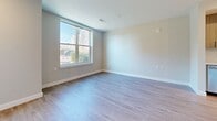 Located at 290 Revolution Drive in Somerville, MA, this modern two-floor residence offers a thoughtfully designed interior with a cohesive, contemporary aesthetic. Light-toned hardwood flooring flows throughout the space, complementing the clean white walls and neutral palette that define the home's overall ambiance.

The kitchen is a standout feature, equipped with stainless steel Samsung appliances including a range, microwave, and dishwasher, alongside a full-size refrigerator. White lower cabinetry pairs with warm wood-toned upper cabinets, and a quartz countertop with a marble-look backsplash adds a refined touch. A kitchen island provides additional prep and seating space.

The living areas are bright and open, with generously sized windows that invite abundant natural light and offer views of the surrounding Somerville neighborhood. Bedrooms are well-proportioned, each featuring large windows that frame outdoor greenery and cityscapes.

Two bathrooms serve the residence: one features a glass-enclosed walk-in shower with white subway tile, while the other includes a full soaking tub with a tiled surround and curved shower rod. Both bathrooms are finished with white vanities and wood-look flooring. An in-unit stacked washer and dryer adds everyday convenience to this well-appointed home.