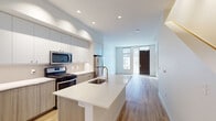 Located at 3195 Bluff St in Boulder, Colorado, this modern multi-floor space spans three levels and showcases a clean, contemporary design aesthetic defined by crisp white walls, light wood-tone flooring, and carefully selected finishes throughout.

The main living area is anchored by an open-concept kitchen featuring a large central island with a white quartz countertop and undermount sink. Stainless steel appliances — including a gas range, over-the-range microwave, and full-size refrigerator — complement two-tone cabinetry with light wood lower cabinets and soft gray uppers, accented by a subtle tile backsplash. Recessed lighting illuminates the space, which flows seamlessly into a bright living area with tall windows and a glass-paneled entry door that invites natural light.

Bedroom spaces are finished with neutral carpet and include walk-in closet storage. Additional rooms with light hardwood flooring offer flexible utility. The bathrooms maintain the same modern sensibility, featuring wood-grain vanities with quartz countertops, large mirrors, and tile flooring. The primary bathroom includes a glass-enclosed walk-in shower with vertical tile detailing, while secondary bathrooms are equipped with tub-shower combinations. The overall ambiance is clean, bright, and contemporary.