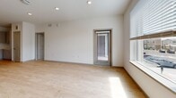 This modern 2-bedroom, 2-bathroom residence in Denver, CO is thoughtfully laid out across a single floor, offering a bright and clean aesthetic throughout. The open-concept living area and kitchen are anchored by light hardwood flooring and recessed lighting, creating a welcoming, airy atmosphere. Large windows fitted with horizontal blinds flood the space with natural light while providing views of the surrounding neighborhood. A door from the living area leads directly to a private balcony, extending the living space outdoors.

The kitchen is a standout feature, boasting gray flat-front cabinetry, white tile backsplash, white quartz countertops, a central island with a sink, and a full suite of stainless steel appliances including a refrigerator, electric range, and over-the-range microwave. Both bedrooms are carpeted and offer a calm retreat, with the primary bedroom featuring direct access to a walk-in closet and an en-suite bathroom. The bathrooms are finished with light hardwood-style flooring, modern gray vanities, and clean white fixtures — one featuring a tub-shower combination with white subway tile surround. A dedicated hallway and closet round out this efficiently organized and well-appointed home.