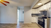 This single-floor, 3-bedroom, 2-bathroom home offers a thoughtfully arranged layout with modern updates throughout. Light gray walls and luxury vinyl plank flooring run consistently across the living spaces, creating a clean, cohesive aesthetic.

The open living and dining area is bright and airy, featuring a ceiling fan and a glass-paned exterior door that invites natural light into the space. The kitchen is efficiently designed with white shaker-style cabinetry, marble-look quartz countertops, a double stainless steel sink, a gas range, and a stainless steel refrigerator. A striking glass tile backsplash in shades of gray and blue adds a contemporary accent.

The primary bedroom is generously proportioned with a ceiling fan, a mirrored sliding closet, and its own access to a dedicated bathroom. The two additional bedrooms also feature ceiling fans and closets, offering comfortable and functional spaces. Each room benefits from the consistent flooring that flows throughout the home.

The bathrooms are well-appointed: one features marble-look tile surrounding a tub-shower combo with a sliding glass door and chrome fixtures, while the second includes a white vanity with a round mirror. Four total closets throughout the home provide exceptional storage capacity for a residence of this scale.