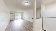 Located on Wyandotte Street in the Reseda neighborhood of Los Angeles, this one-bedroom, one-bathroom unit offers a practical and well-appointed layout across a single floor. Light wood-look flooring runs throughout, lending a clean, cohesive aesthetic to the entire space.

The living room serves as the central gathering area, featuring a wall-mounted air conditioning unit and a sliding glass door that opens to an outdoor view, allowing natural light to fill the room. The textured ceiling adds a classic residential character consistent throughout the unit.

The bedroom is a comfortable, well-proportioned room highlighted by a natural light source from a window with blinds. A set of mirrored sliding closet doors provides ample storage while visually expanding the space.

The bathroom is clean and functional, featuring light wood-look flooring that matches the rest of the unit, a full-size tub and shower combo with chrome grab bars and a handheld showerhead, and a standard toilet. The neutral white palette keeps the space feeling bright and fresh.

The kitchen, visible in the floorplan, completes the layout. Overall, the unit presents a bright, neutral interior with consistent finishes throughout, making it a practical and move-in-ready space in the heart of the San Fernando Valley.