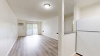 Located on Wyandotte Street in the Reseda neighborhood of Los Angeles, this one-bedroom, one-bathroom unit offers a practical and well-appointed layout across a single floor. Light wood-look flooring runs throughout, lending a clean, cohesive aesthetic to the entire space.

The living room serves as the central gathering area, featuring a wall-mounted air conditioning unit and a sliding glass door that opens to an outdoor view, allowing natural light to fill the room. The textured ceiling adds a classic residential character consistent throughout the unit.

The bedroom is a comfortable, well-proportioned room highlighted by a natural light source from a window with blinds. A set of mirrored sliding closet doors provides ample storage while visually expanding the space.

The bathroom is clean and functional, featuring light wood-look flooring that matches the rest of the unit, a full-size tub and shower combo with chrome grab bars and a handheld showerhead, and a standard toilet. The neutral white palette keeps the space feeling bright and fresh.

The kitchen, visible in the floorplan, completes the layout. Overall, the unit presents a bright, neutral interior with consistent finishes throughout, making it a practical and move-in-ready space in the heart of the San Fernando Valley.