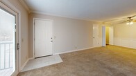 Located at 1751 Ashland City Rd in Clarksville, Tennessee, this single-floor, 2-bedroom, 2-bathroom residence offers a thoughtfully designed layout with quality finishes throughout. The combined living and dining area provides a generous, open feel, complete with plush carpeting, crown molding, a ceiling fan, and classic wainscoting detail. Tile flooring at the entry transitions seamlessly into the carpeted main living space, and sliding glass doors lead out to a private balcony with outdoor views. The kitchen is well-equipped, featuring crisp white raised-panel cabinetry, dark granite countertops, a mosaic tile backsplash, tile flooring, and black appliances including a refrigerator, range, microwave, and dishwasher. Both bedrooms are carpeted and offer comfortable proportions, with the primary bedroom providing direct access to its own bathroom. The two bathrooms are elegantly finished with large-format marble-look tile flooring and tub surrounds with subway-style tile detailing, paired with cream-toned vanities and brushed nickel hardware. Additional spaces include a laundry area, utility room, multiple closets, and hallways that connect the layout efficiently. Textured ceilings and crown molding are consistent throughout, lending a cohesive, polished character to the entire residence.