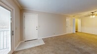 Located at 1751 Ashland City Rd in Clarksville, Tennessee, this single-floor, 2-bedroom, 2-bathroom residence offers a thoughtfully designed layout with quality finishes throughout. The combined living and dining area provides a generous, open feel, complete with plush carpeting, crown molding, a ceiling fan, and classic wainscoting detail. Tile flooring at the entry transitions seamlessly into the carpeted main living space, and sliding glass doors lead out to a private balcony with outdoor views. The kitchen is well-equipped, featuring crisp white raised-panel cabinetry, dark granite countertops, a mosaic tile backsplash, tile flooring, and black appliances including a refrigerator, range, microwave, and dishwasher. Both bedrooms are carpeted and offer comfortable proportions, with the primary bedroom providing direct access to its own bathroom. The two bathrooms are elegantly finished with large-format marble-look tile flooring and tub surrounds with subway-style tile detailing, paired with cream-toned vanities and brushed nickel hardware. Additional spaces include a laundry area, utility room, multiple closets, and hallways that connect the layout efficiently. Textured ceilings and crown molding are consistent throughout, lending a cohesive, polished character to the entire residence.