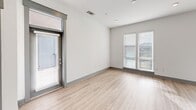 This contemporary 840 square foot apartment in Charlotte, NC offers a well-designed living space with a focus on functionality and style. The open-concept floor plan seamlessly integrates the kitchen, living, and dining areas, creating a spacious feel within the compact layout. The kitchen is a standout feature, boasting sleek gray cabinetry, stainless steel appliances, and a convenient center island with a white countertop. A unique X-shaped wine rack adds a touch of sophistication.

The bedroom, measuring 200 square feet, is generously sized and features plush carpeting and a ceiling fan for comfort. Large windows allow ample natural light to flood the space, while providing city views. The bathroom is modern and bright, with a double vanity and clean, white finishes.

Throughout the apartment, you'll find a harmonious blend of materials, including warm wood-look flooring in the main living areas and soft carpeting in the bedroom. The neutral color palette, dominated by whites and grays, creates a fresh and inviting atmosphere. Recessed lighting and pendant fixtures add to the contemporary ambiance.

Storage solutions are thoughtfully integrated, with a walk-in closet off the bedroom and additional built-in storage in the kitchen. The apartment's design maximizes every square foot, offering a comfortable and efficient living space in the heart of Charlotte.