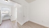 Located at 21 E Seventh St in Hialeah, Florida, this efficient studio unit is thoughtfully laid out across a single floor, making smart use of every square foot. The interior is finished throughout with light hardwood-style flooring that lends a clean, cohesive look to the entire space.

The combined living and kitchen area forms the heart of the unit. The living portion is open and uncluttered, with bright white walls and a window fitted with horizontal blinds that allows natural light to filter in. The kitchen is accessed through an open passageway and is equipped with a full-size refrigerator and range, with additional counter space along the wall and a window providing ventilation and light.

A dedicated closet offers practical storage, while the bathroom is privately positioned to the rear of the unit. The consistent use of white throughout the walls and trim creates a bright, airy atmosphere that maximizes the sense of space. The front entry door opens directly into the main living area, enhancing the open and accessible feel of the layout.

This unit's straightforward design, updated flooring, and functional kitchen make it a practical option in a well-connected Hialeah location.