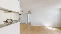 Located on Saint Johns Bluff Road South in Jacksonville, FL, this one-bedroom, one-bathroom unit offers a well-organized single-floor layout with a clean, neutral aesthetic throughout. The open living area is finished with light wood-style flooring and features a textured ceiling, crisp white walls, and a window fitted with horizontal blinds that allows natural light to fill the space.

The kitchen is thoughtfully designed with dark espresso cabinetry, granite countertops, a stainless steel sink, and a full suite of stainless steel appliances including a refrigerator, range, microwave, and dishwasher. A pass-through breakfast bar connects the kitchen to the living area, enhancing the open feel. In-unit laundry is conveniently tucked nearby, behind louvered closet doors.

The bedroom is carpeted for comfort and features two windows overlooking a lush, green outdoor setting, providing pleasant natural views and ample daylight. A dedicated closet offers practical storage.

The bathroom is well-appointed with dark wood cabinetry, granite countertops, a mirrored vanity, and a shower-tub combo with white tile surround. Light wood-style flooring continues into the bathroom, maintaining a cohesive look throughout the unit.