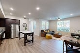 Located at 2740 E Shepherd Ave in Fresno, CA, this single-story, one-bedroom, one-bathroom residence offers a thoughtfully designed open-concept layout. Light wood-style flooring flows through the main living areas, complemented by recessed lighting and ceiling fans that enhance the bright, airy atmosphere.

The kitchen and living room share a seamless open floor plan, making the space feel expansive and connected. The kitchen features rich dark-espresso cabinetry, crisp white quartz countertops, a full suite of stainless steel appliances including a gas range, built-in microwave, dishwasher, and refrigerator, plus a breakfast bar ideal for casual dining. Large windows in the living area flood the space with natural light and provide views of the surrounding greenery.

The generously sized primary bedroom is carpeted for comfort, includes a ceiling fan, and features a large window with outdoor views. An adjacent walk-in closet offers multi-tier hanging rods and shelving for ample storage. The full bathroom is finished with dark cabinetry matching the kitchen, a white vanity countertop, a large mirror, and wood-style tile flooring. A hallway connects the private quarters to the main living areas, completing the efficient and functional layout.