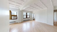 Located in Chicago's prestigious Gold Coast neighborhood, this 2-bedroom, 2-bathroom residence at 1211 North La Salle Drive offers a well-designed layout across a single floor. A defining architectural feature throughout the home is the striking coffered ceiling detail, which lends a classic, sophisticated character to the living spaces.

The combined living and dining area is bright and open, with large windows framing city views and allowing generous natural light to fill the room. Light-toned hardwood flooring flows consistently throughout, adding warmth and cohesion.

The galley-style kitchen is thoughtfully updated, featuring white cabinetry with wood open shelving, quartz countertops with a marble-inspired finish, a stainless steel sink with a modern brushed-nickel faucet, and stainless steel appliances including a full-size refrigerator.

Both bedrooms are well-proportioned, each with coffered ceilings, hardwood floors, and closet storage. The primary bedroom offers generous square footage with city-facing windows.

The two bathrooms are distinctly appointed. One features a walnut vanity with gold hardware, white quartz countertop, and marble-style tile flooring. The second includes a soaking tub with white tile surround and a warm wood vanity. The unit also includes an in-unit laundry area and four closets for ample storage throughout.