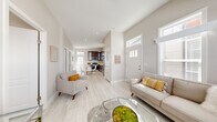 Located at 8250 Lankershim Blvd in Los Angeles, CA, this thoughtfully designed 2-bedroom, 2-bathroom residence offers a bright and modern living experience across a single floor. The open layout connects a welcoming living room to the kitchen and dining area, creating a cohesive flow throughout the space. The living room stands out with soaring ceilings, oversized windows with transom panels that flood the area with natural light, and light wood-look tile flooring that extends seamlessly throughout the home. A kitchen anchors the back of the unit, featuring rich dark espresso cabinetry with glass-front upper panels, white quartz countertops, stainless steel appliances including a refrigerator and built-in microwave, and a bright window above the sink. A compact dining area sits adjacent to the kitchen. Both bedrooms are well-proportioned and naturally lit, with multiple windows framing neighborhood views, neutral wall tones, and the same light-toned tile flooring. The two bathrooms are clean and functional — one features a full tub-shower combination with white tile surround, while the other offers a pedestal sink and medicine cabinet. Throughout, the neutral color palette, recessed lighting, and consistent finishes create a cohesive, modern ambiance well-suited for comfortable urban living.