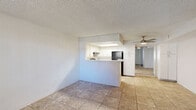 Located at 3535 West Tierra Buena Lane in Phoenix, AZ, this single-story, one-bedroom, one-bathroom residence offers a practical and well-organized layout. The living area greets you with neutral-toned tile flooring, white walls, and a textured ceiling, creating a clean and bright atmosphere. A sliding glass door fitted with vertical blinds opens to a private outdoor patio, filling the space with natural light and providing views of the surrounding landscape. A front entry door and a window with vertical blinds further enhance ventilation and light.

The kitchen is thoughtfully designed with a pass-through counter that connects it to the living area, promoting an open feel. White cabinetry offers ample storage, while a skylight overhead adds an extra dimension of brightness. Black appliances, including a refrigerator and electric range, provide a sharp contrast against the white finishes, and tile flooring ties the kitchen seamlessly to the main living space.

The bedroom features plush carpeting and a sliding mirrored closet door that adds depth to the room. A ceiling fan ensures comfort year-round. The bathroom is conveniently positioned adjacent to a stacked in-unit washer and dryer, maximizing functionality within the compact footprint. Tile flooring extends throughout the bathroom, maintaining a cohesive aesthetic throughout the home.