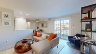 This single-floor residence offers a thoughtfully designed layout that blends comfort and modern style throughout. The open-concept living area is bright and welcoming, anchored by large sliding glass doors that invite natural light and provide access to an outdoor balcony with exterior views. Light hardwood-style flooring runs seamlessly throughout the main living spaces, complementing the neutral wall tones that give the home a clean, airy feel. A ceiling fan overhead adds both function and a casual design touch to the living space.

Adjacent to the living area, the dedicated dining space accommodates a round table and seating for four, accented by framed wall art and a ceiling fan. The kitchen features contemporary wood-grain cabinetry, white countertops, and a full suite of white appliances including a range, over-the-range microwave, dishwasher, and refrigerator — all finished with light flooring for a cohesive look.

The bedroom is generously sized with a double closet, a window with natural light, and neutral tones that create a calm retreat. The bathroom is finished with large-format tile flooring and wall surround, a sliding glass tub-shower enclosure, and a sleek white vanity with modern hardware. A closet with built-in storage rounds out the practical features of this well-balanced residence.