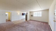 Located at 9101 New Falls Rd in Levittown, PA, this one-bedroom, one-bathroom residence offers a well-organized single-floor layout designed for comfortable everyday living. The open living and dining area is a welcoming space featuring a mix of plush carpeting and easy-care hardwood-style flooring, with a window that brings in natural light and views of the surrounding greenery. Baseboard heating runs throughout, and a wall-mounted A/C unit serves the main living area for year-round comfort. A textured ceiling adds a classic touch to the neutral, light-toned walls throughout.

The kitchen is efficiently designed in an L-shaped configuration, outfitted with rich dark espresso cabinetry, granite-style countertops, stainless steel appliances including a refrigerator, range, and dishwasher, and a window above the sink. Light wood-style flooring completes the clean, functional look.

The bedroom is a generously sized, carpeted retreat featuring a large closet, baseboard heating, and a window overlooking the outdoors. In total, the home offers three closets, providing ample storage throughout. The bathroom is finished with white subway tile, a decorative mosaic tile accent border, a tub-shower combination, and a vanity with mirror. A hallway connects all areas of the home seamlessly.