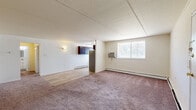 Located at 9101 New Falls Rd in Levittown, PA, this one-bedroom, one-bathroom residence offers a well-organized single-floor layout designed for comfortable everyday living. The open living and dining area is a welcoming space featuring a mix of plush carpeting and easy-care hardwood-style flooring, with a window that brings in natural light and views of the surrounding greenery. Baseboard heating runs throughout, and a wall-mounted A/C unit serves the main living area for year-round comfort. A textured ceiling adds a classic touch to the neutral, light-toned walls throughout.

The kitchen is efficiently designed in an L-shaped configuration, outfitted with rich dark espresso cabinetry, granite-style countertops, stainless steel appliances including a refrigerator, range, and dishwasher, and a window above the sink. Light wood-style flooring completes the clean, functional look.

The bedroom is a generously sized, carpeted retreat featuring a large closet, baseboard heating, and a window overlooking the outdoors. In total, the home offers three closets, providing ample storage throughout. The bathroom is finished with white subway tile, a decorative mosaic tile accent border, a tub-shower combination, and a vanity with mirror. A hallway connects all areas of the home seamlessly.