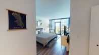 Located in Chicago's vibrant River West neighborhood, this single-floor studio at 840 W Blackhawk St offers a well-appointed and thoughtfully designed living space. The main living area is anchored by floor-to-ceiling sliding glass doors that flood the room with abundant natural light and provide direct access to a private balcony, offering open outdoor views of the surrounding cityscape. Warm hardwood flooring extends throughout the main space, complementing the clean, modern aesthetic defined by crisp white walls and contemporary finishes. The sleeping area is generously proportioned, accommodating a full-size bed with ease, and features dual closets with built-in shelving and hanging rods, providing ample storage. Track lighting near the entry enhances the unit's functionality, while the open layout allows for flexible furniture arrangement. The bathroom is finished with light tile flooring, a dark espresso vanity topped with granite countertops, a wide mirror with overhead lighting, and a separate shower enclosure. The overall ambiance is modern, bright, and efficient—ideal for urban living in one of Chicago's dynamic and well-connected neighborhoods.