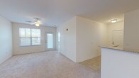This single-floor residence offers three bedrooms and two bathrooms within a thoughtfully arranged layout. The living area is carpeted in neutral tones and benefits from natural light provided by a large window and a glass-paneled exterior door, which also offers access to an outdoor area. A ceiling fan with a light fixture provides additional comfort and illumination. Adjacent to the living space, the kitchen features warm-toned wood cabinetry, granite-style countertops, tile flooring, and black appliances including a range, microwave, and dishwasher, along with a double-basin sink.

Each of the three bedrooms is finished with plush carpeting and ceiling fan light fixtures. Two of the bedrooms feature windows with blinds that allow natural light and outdoor views, while all bedrooms include closet space. The primary bedroom is notably spacious with direct access to its own bathroom area.

The two bathrooms are finished with tile flooring. One features a double-sink vanity with wood cabinetry, a large mirror, and a shower-tub combination. The second bathroom includes a single vanity and a shower-tub combination. Throughout, the space maintains a clean, neutral palette that lends itself to versatile use.