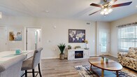 Located in Clarksville, Tennessee, this well-appointed one-bedroom, one-bathroom residence offers a thoughtfully designed single-floor layout with a warm, contemporary aesthetic throughout. Wood-look plank flooring flows seamlessly across all rooms, creating a cohesive and clean visual foundation.

The living room is bright and inviting, featuring a ceiling fan, an electric fireplace, and a glass door that opens to a private outdoor balcony, allowing natural light to fill the space. The kitchen is well-equipped with grey shaker-style cabinetry, stainless steel appliances including a range, over-the-range microwave, refrigerator with ice maker, and dishwasher, along with light countertops, a decorative pendant light, and a tile backsplash.

The generously sized primary bedroom offers a ceiling fan, ample natural light from multiple windows, and direct access to the bathroom. The en-suite bathroom features a large vanity with quartz-style countertops, grey cabinetry, a tub/shower combination, and accessibility-friendly grab bars. Upper cabinetry provides additional storage. Neutral tones and clean finishes throughout the space contribute to a calm, functional ambiance well-suited for comfortable everyday living.