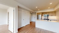 Located at 1110 W Columbia Way in Vancouver, WA, this thoughtfully designed one-bedroom, one-bathroom unit offers a modern and efficient living experience across a single floor. The open-concept layout seamlessly connects the kitchen and living area, creating a bright and cohesive space ideal for everyday living.

The kitchen is a standout feature, equipped with stainless steel Whirlpool appliances including a range, over-the-range microwave, and refrigerator. Light wood cabinetry with matte black hardware complements the white quartz countertops and a herringbone tile backsplash. A central island with a built-in sink adds both prep space and visual appeal.

Warm wood-look flooring runs throughout the unit, tying each room together cohesively. The living area is bathed in natural light through large windows and a glass door that opens to a private balcony, offering open views of the surrounding landscape and Vancouver skyline.

The bedroom is a comfortable retreat featuring a large window that frames outdoor greenery and city views, with recessed lighting and ample wall space. The bathroom is clean and contemporary, finished with large-format marble-look tile in the tub and shower surround, complemented by matte black fixtures and accessories. The overall ambiance is bright, modern, and move-in ready.