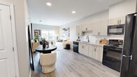 Located at 527 Herndon Square Ave, Unit 504 in Atlanta, GA, this two-bedroom, one-bathroom residence offers a well-designed single-floor layout with consistent modern finishes throughout. The open-concept kitchen and living area serves as the heart of the home, where light wood-tone cabinetry with matte black hardware pairs with granite-style countertops, a white subway tile backsplash, and black appliances including a range, microwave, dishwasher, and refrigerator. The living room benefits from a large window that brings in natural light and frames neighborhood views, complemented by wood-style plank flooring that extends throughout the space. Both bedrooms are comfortably scaled, with the primary bedroom offering a window with outdoor views and ample room for full-sized furniture. The second bedroom also features wood-style flooring and practical closet access. The bathroom is outfitted with a full soaking tub and shower combination featuring built-in shelving and brushed gold fixtures set against clean white surroundings. Neutral wall tones throughout the residence create a cohesive, calm ambiance that adapts well to a variety of interior styles.