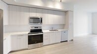 This 640 square foot apartment in Boca Raton, FL offers a thoughtfully designed living space on a single floor. The modern kitchen is a standout feature, boasting sleek white cabinetry, stainless steel appliances, and a functional layout. It includes a side-by-side refrigerator, built-in microwave, and electric range, all complemented by ample counter space and a single-basin sink.

The 140 square foot bedroom is generously sized, featuring a large window that allows natural light to flood the space. The room is equipped with a ceiling fan and offers enough space for a queen-sized bed and additional furniture. A spacious closet with wire shelving provides abundant storage options.

The bathroom is well-appointed with a modern vanity, large mirror, and a combined shower-tub unit. Light-colored tile extends from the floor to the shower walls, creating a cohesive and bright appearance.

Throughout the apartment, light wood-look flooring adds warmth and continuity. The neutral color palette, predominantly whites and light grays, creates a clean and contemporary aesthetic. The open concept living area seamlessly connects to the kitchen, maximizing the use of space in this efficient floor plan.

A hallway provides access to all rooms and includes additional storage solutions. The apartment's layout is designed to optimize every square foot, making it an ideal choice for those seeking a modern, low-maintenance living space in a desirable Boca Raton location.