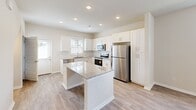 Located at 270 Wild Palm Way in Conway, SC, this two-story home offers a well-designed layout spread across two floors. The main level features an open-concept living and kitchen area bathed in natural light from multiple windows. The kitchen is a standout, showcasing crisp white shaker cabinetry, a granite-topped center island, stainless steel appliances including a refrigerator, range, microwave, and dishwasher, and light wood-look flooring that extends throughout the main level. A ceiling fan overhead and recessed lighting add both comfort and style to the open living area.

Upstairs, three carpeted bedrooms provide quiet retreats, each equipped with ceiling fans and natural light from well-placed windows. The primary bedroom is generously sized and includes access to a walk-in closet fitted with wire shelving for ample storage. The primary bathroom features a glass-enclosed shower, a granite-topped double vanity with white cabinetry, and light wood-look flooring. A second full bathroom on the upper level offers a tub-shower combination with white tile surround and a matching granite vanity. Three closets in total serve the home's storage needs. The home's neutral palette and modern finishes create a bright, cohesive atmosphere throughout.