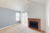Located at 9937 E Louisiana Dr in Aurora, CO, this one-bedroom, one-bathroom home offers a thoughtfully laid-out single-floor plan that maximizes every square foot. The living room immediately impresses with dramatic vaulted ceilings accented by exposed beams, creating an airy, open atmosphere. A standout brick fireplace with a tile hearth anchors the space, complemented by a sliding glass door and adjacent window that invite abundant natural light. The entry features classic brick-patterned tile flooring that transitions seamlessly into plush carpeting throughout the main living areas. The kitchen is equipped with warm-toned wood cabinetry, a granite-topped peninsula that opens to the living area, a range, and a refrigerator, all beneath a skylight that brightens the space. The bedroom is generously sized, featuring a ceiling fan, two windows for cross-ventilation, and access to a dedicated closet. A second carpeted room with a ceiling fan and bold accent wall offers additional flexible space. The bathroom includes a full tub-shower combination with clean white tile surrounds. Throughout the home, a cohesive color palette of soft grays and whites lends a calm, neutral ambiance well-suited for comfortable everyday living.