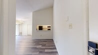 This 860-square-foot, single-floor apartment at 200 Foxhall Dr in Bel Air, MD offers a practical and comfortable layout with 2 bedrooms, 1 bathroom, a kitchen, living room, closet, and hallway. Wide-plank wood-look flooring runs consistently throughout the entire unit, lending a clean, cohesive aesthetic to every room. The spacious living room features a chandelier, a textured ceiling, and large sliding glass doors that open to an outdoor balcony, flooding the space with natural light and providing views of surrounding greenery. An adjacent pass-through connects the living area to the kitchen, which is equipped with black appliances including an electric range and dishwasher, white cabinetry, and a marble-look countertop. The primary bedroom measures 210 square feet and includes a built-in closet and a large window overlooking wooded scenery. The second bedroom also features a built-in closet and ample natural light. A hallway connects the bedrooms to the full bathroom, which is appointed with a white vanity, tub/shower combo with tile surround, and wood-look flooring. A dedicated closet provides additional storage. The unit's neutral color palette and updated finishes create a clean, move-in-ready environment throughout.