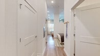 Located at 1647 E Colonial Drive in Orlando, Florida, this thoughtfully designed studio offers an efficient single-floor layout that maximizes every square foot. The open-plan living and kitchen area is anchored by impressively tall ceilings that lend a sense of spaciousness well beyond the unit's footprint, complemented by large windows that flood the interior with abundant natural light and offer views of the surrounding streetscape.

The kitchen is a standout feature, showcasing a clean, modern aesthetic with two-tone cabinetry — warm natural wood lower cabinets paired with crisp white upper cabinets — set against a striking hexagonal tile backsplash. Stainless steel appliances, including a French-door refrigerator, electric range, built-in microwave, and dishwasher, complete this functional yet stylish culinary space. Light hardwood-style flooring flows seamlessly throughout, tying the entire space together.

The living area benefits from the soaring ceiling height, creating an airy, loft-like atmosphere. Soft, neutral wall tones provide a versatile backdrop, while sheer floor-to-ceiling drapes frame the windows elegantly. A hallway leads to the sleeping area, which features a ceiling fan and access to natural light, while a coat hook station near the entry adds practical convenience. Recessed lighting throughout ensures a bright, well-lit environment at all hours.