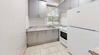 Located at 549 North Service Road in Mississauga, Ontario, this one-bedroom, one-bathroom unit offers a thoughtfully organized layout across a single floor. The entrance leads into an open living and dining area finished with warm parquet hardwood flooring, white walls, and flush ceiling lighting that keeps the space feeling bright and clean.

The kitchen is efficiently designed with gray lower and upper cabinetry, granite-patterned countertops, a stainless steel sink, and a window that brings in natural light and a view of surrounding greenery. A peninsula counter extends into the dining area, providing additional prep space and a natural division between the kitchen and living zones. A white range and refrigerator complete the functional appliance suite, while light tile flooring grounds the kitchen area.

The spacious primary bedroom accommodates the majority of the unit's footprint, featuring the same warm parquet flooring, dual windows that frame outdoor tree views, a baseboard heater, and a closet for storage. The textured ceiling adds subtle architectural character throughout the unit.

The bathroom is clean and well-appointed, with a granite-finish vanity countertop, an integrated sink, a toilet, and a tiled bathtub enclosure with wood-toned flooring. A dedicated closet near the entrance provides additional storage. The overall ambiance is practical, tidy, and move-in ready.