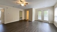 This contemporary apartment offers 770 square feet of thoughtfully designed living space. The open-concept layout combines the living room and kitchen, creating a spacious feel enhanced by dark wood-look flooring and ample natural light from large windows. The updated kitchen features white appliances and cabinetry. Two bedrooms, including a 160 sq ft primary, offer plush carpeting and ceiling fans. Two full bathrooms boast modern fixtures and tub/shower combinations. Additional amenities include a ceiling fan in the main living area, window blinds throughout, and a private entrance. The neutral color palette provides a blank canvas for personalization.