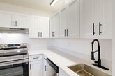 Located at 2725 Somerset Dr in Lauderdale Lakes, FL, this well-appointed 1-bedroom, 1-bathroom residence offers a clean, modern aesthetic throughout. Light-toned luxury vinyl plank flooring flows seamlessly across the entire space, complementing the crisp white walls and creating a bright, airy atmosphere.

The open-plan living and dining area is generously sized, bathed in natural light from large sliding glass doors that lead to a private balcony overlooking a lush, tree-lined outdoor view. A contemporary multi-arm light fixture anchors the ceiling, adding a stylish focal point to the room.

The kitchen is thoughtfully designed with white shaker-style cabinetry, black hardware accents, light quartz countertops, and a full suite of stainless steel appliances including a refrigerator, range, and dishwasher. A deep sink with a matte black faucet completes this functional and attractive space.

The bedroom is comfortably proportioned, featuring a window with natural light and a modern ceiling light fixture. Three closets provide ample storage throughout the unit.

The bathroom features wood-look flooring, a tub/shower combination with marble-style tile surround, black hardware accents, and a white vanity. A hallway connects the key areas of this well-organized, move-in ready residence.