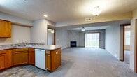 Located at 2806 Rainbow Ave in Bloomington, Illinois, this well-appointed 2-bedroom, 2-bathroom residence offers comfortable single-floor living with a thoughtfully designed layout. The open-concept kitchen, dining, and living area forms the heart of the home, creating a seamless flow ideal for daily living and entertaining. The kitchen features warm oak cabinetry, granite-look laminate countertops, a peninsula with additional counter space, stone-tile flooring, and a full suite of appliances including a stainless steel refrigerator and electric range. The spacious living room is highlighted by a gas fireplace with a green marble surround, plush carpeting, a ceiling fan, and a sliding glass door that opens to a private patio with outdoor views. Both bedrooms are generously sized, each equipped with ceiling fans, plush carpet, and windows that bring in natural light. The primary bedroom is notably spacious and includes closet storage. Both bathrooms are functionally designed with oak vanities, tub/shower combos, and stone-tile flooring. Additional highlights include an in-unit laundry area and an abundance of closet space throughout. Textured ceilings and warm wood trim add character throughout this well-organized home.