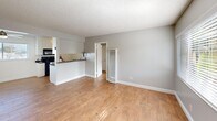 Located at 680 Evergreen Ln in Port Hueneme, California, this single-floor, one-bedroom, one-bathroom unit offers a well-organized and functional layout. The open-concept living, dining, and kitchen area is a central highlight, featuring warm wood-look flooring, neutral gray walls, and a textured ceiling throughout. Natural light filters in through slatted blinds, creating a bright and welcoming atmosphere. A ceiling fan adds comfort to the living and dining space.

The galley-style kitchen is efficiently designed with abundant white cabinetry, dark granite-style countertops, a double sink, and black appliances including an electric range with over-the-range microwave. The kitchen opens directly to the main living area via a pass-through counter, making the space feel connected and accessible.

The bedroom is a comfortable size, benefiting from a window with natural light and direct access to closet space. The unit includes three closets in total, providing generous storage throughout. The bathroom features a tub and shower combination with elegant marble-style tile surround and chrome fixtures, complemented by a window for natural ventilation.

The clean, move-in-ready condition and practical layout make this Port Hueneme unit an efficient and comfortable living space.