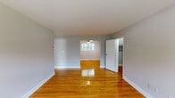 Located at 407 Kingston Terrace Drive in Princeton, NJ, this single-floor, one-bedroom, one-bathroom unit offers a thoughtfully organized layout across a comfortable footprint. Warm-toned hardwood floors run throughout the main living and bedroom areas, lending a cohesive and inviting character to the space.

The main living area is open and airy, with neutral gray walls, clean white trim, and a ceiling fan overhead. Natural light filters in through a window in the dining alcove, which is defined by the same hardwood flooring and connects naturally to the adjacent kitchen. The kitchen features light-toned flooring, dark wood cabinetry, and includes a full-size refrigerator, providing practical functionality in a compact space.

The bedroom is generously sized and includes two sliding-door closets with built-in hanging rods, offering ample storage. A window provides natural light, and the hardwood floors continue throughout. The hallway entry area features dual doors and additional switching, creating a practical transitional zone.

The bathroom is finished with tile flooring, a dark wood vanity with white countertop, a mirrored medicine cabinet with lighted fixture above, and a shower. The overall aesthetic throughout is clean, neutral, and move-in ready.