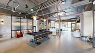 Located at 1015 Boulevard SE in Atlanta's Grant Park neighborhood, this single-floor amenity space blends industrial design with contemporary comfort. Soaring exposed ceilings reveal a network of ductwork and conduit overhead, complemented by polished concrete floors that flow throughout the expansive open layout.

The main lounge area is anchored by a curated mix of seating — including a soft pink sofa, rounded ivory armchairs, and colorful accent ottomans — arranged around a sculptural wood coffee table. Exposed brick walls and mounted flat-screen TVs add character and function. The space transitions seamlessly into a game area centered on a substantial billiards table beneath stylish pendant lighting.

A dedicated dining zone features a grand communal table, banquette seating, and elegant gold chandeliers, creating an upscale yet welcoming atmosphere. Floor-to-ceiling windows and glass doors along one wall flood the space with natural light and offer views of the outdoor pool area beyond.

A glass-enclosed private room with vibrant red-toned flooring and a crystal chandelier serves as a refined conference or meeting space. A well-appointed kitchenette with hexagonal tile flooring, open shelving, and stainless steel appliances supports event and gathering needs. Throughout, the design balances industrial rawness with warm, stylish furnishings.