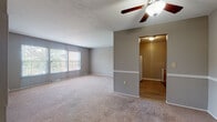 This single-floor, two-bedroom, two-bathroom home in Rocky River, Ohio offers a practical and comfortable layout with a neutral color palette throughout. The living room is a standout space, anchored by a full brick fireplace that reaches toward the ceiling, complemented by large windows that invite generous natural light and views of the surrounding greenery. Plush wall-to-wall carpeting and a ceiling fan add comfort and functionality to the living and dining areas, which flow openly toward the kitchen.

The kitchen features warm wood-toned cabinetry, granite-look countertops, a double sink, and wood-look plank flooring, providing both practicality and visual contrast to the carpeted main areas. Appliances including a refrigerator, dishwasher, and range are included.

Both bedrooms are generously sized, carpeted, and painted in soft gray tones. The primary bedroom benefits from dual windows on separate walls, filling the room with natural light. Each bedroom offers closet storage, with one featuring a spacious double-door closet. The bathrooms are cleanly finished with white vanities, tile-surround tub/shower combinations, and wood-look flooring, maintaining a cohesive and tidy aesthetic throughout the home.